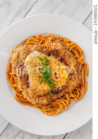 Crispy Chicken Parmesan served over spaghetti with marinara melted cheese and fresh chives 143980021