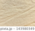 beige wrinkled linen texture provides organic sustainable fabric background displaying rustic weave pattern for minimalist web design and advertising highlighting calm natural authenticity 143980349