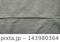 raw gray denim fabric texture featuring a distinct horizontal seam for sustainable fashion web design backgrounds and authentic textile patterns creating a minimalist aesthetic appeal 143980364