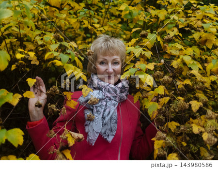 Happy senior woman in pink coat smiling outdoors in autumn park. Active elderly lifestyle, healthy aging and seasonal wellness concepts. Happy senior woman in pink coat smiling outdoors in autumn park. Active elderly lifestyle, healthy aging and seasonal wellness concepts. 143980586