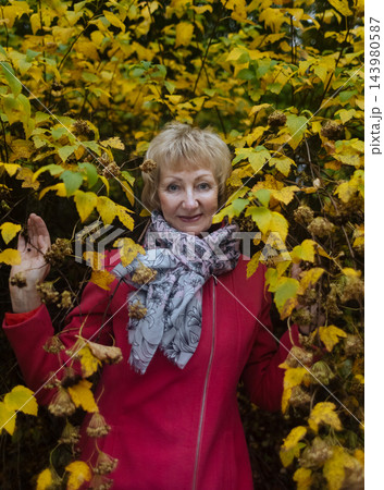 Happy senior woman in pink coat smiling outdoors in autumn park. Active elderly lifestyle, healthy aging and seasonal wellness concepts. Happy senior woman in pink coat smiling outdoors in autumn park. Active elderly lifestyle, healthy aging and seasonal wellness concepts. 143980587