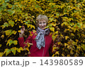 Happy senior woman in pink coat smiling outdoors in autumn park. Active elderly lifestyle, healthy aging and seasonal wellness concepts. Happy senior woman in pink coat smiling outdoors in autumn park. Active elderly lifestyle, healthy aging and seasonal wellness concepts. 143980589
