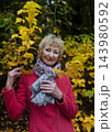 Happy senior woman in pink coat smiling outdoors in autumn park. Active elderly lifestyle, healthy aging and seasonal wellness concepts. Happy senior woman in pink coat smiling outdoors in autumn park. Active elderly lifestyle, healthy aging and seasonal wellness concepts. 143980592
