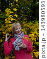 Happy senior woman in pink coat smiling outdoors in autumn park. Active elderly lifestyle, healthy aging and seasonal wellness concepts. Happy senior woman in pink coat smiling outdoors in autumn park. Active elderly lifestyle, healthy aging and seasonal wellness concepts. 143980593