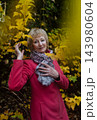 Happy senior woman in pink coat smiling outdoors in autumn park. Active elderly lifestyle, healthy aging and seasonal wellness concepts. Happy senior woman in pink coat smiling outdoors in autumn park. Active elderly lifestyle, healthy aging and seasonal wellness concepts. 143980604