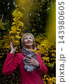 Happy senior woman in pink coat smiling outdoors in autumn park. Active elderly lifestyle, healthy aging and seasonal wellness concepts. Happy senior woman in pink coat smiling outdoors in autumn park. Active elderly lifestyle, healthy aging and seasonal wellness concepts. 143980605