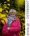 Happy senior woman in pink coat smiling outdoors in autumn park. Active elderly lifestyle, healthy aging and seasonal wellness concepts. Happy senior woman in pink coat smiling outdoors in autumn park. Active elderly lifestyle, healthy aging and seasonal wellness concepts. 143980607