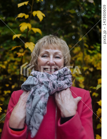 Happy senior woman in pink coat smiling outdoors in autumn park. Active elderly lifestyle, healthy aging and seasonal wellness concepts. Happy senior woman in pink coat smiling outdoors in autumn park. Active elderly lifestyle, healthy aging and seasonal wellness concepts. 143980609