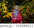 Happy senior woman in pink coat smiling outdoors in autumn park. Active elderly lifestyle, healthy aging and seasonal wellness concepts. Happy senior woman in pink coat smiling outdoors in autumn park. Active elderly lifestyle, healthy aging and seasonal wellness concepts. 143980611