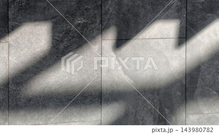 Bright architectural shadows sweep over textured charcoal tiles in a top-down view, creating a calm abstract rhythm. The image reflects natural light, interior design, renovation, and minimalism. 143980782