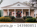 JEFFERSON, TEXAS: A grand beige Southern plantation-style historic home with white columns, grand brick steps, nutcrackers, an American flag, and a Texas flag. 143980851