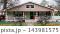 JEFFERSON, TEXAS: A single-story beige home decorated for Christmas with red and white candy cane ribbon wrapped around the porch railings and columns. 143981575