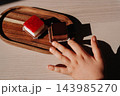 Child hand reaching for chocolate cake next to raspberry cheesecake on wooden board 143985270
