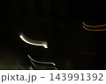 漆黒の背景に流れる街灯の光、ミステリアスな夜の抽象アート 143991392