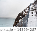 冬の知床・オロンコ岩の雪に覆われた階段とオホーツク海 143994287
