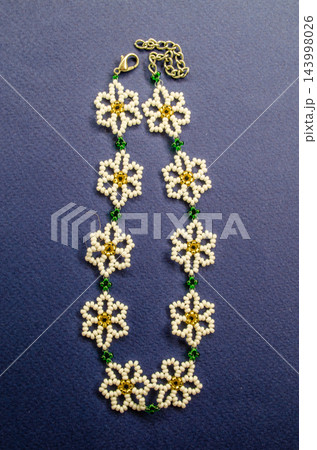 Handmade bead necklace with a chain clasp and linked flower shapes 143998026