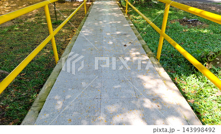 Park Pathway with Yellow Safety Railings 143998492