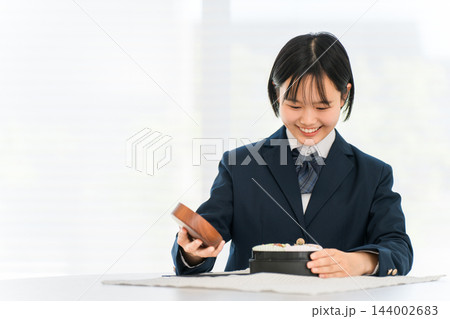 笑顔でお弁当のふたを開ける女子学生 笑顔でお弁当のふたを開ける女子学生 144002683