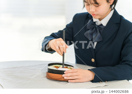 お弁当のおかずを箸で取る女子学生 144002686