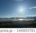 逆光で輝く太陽と海面の光の道 草むらの向こうに山並みのシルエット 写真素材 逆光で輝く太陽と海面の光の道 草むらの向こうに山並みのシルエット 写真素材 144003781