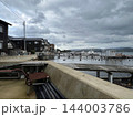 曇り空の下の海辺に建ち並ぶ木造の家々と木製の桟橋 コンクリートの護岸 横位置 写真素材 曇り空の下の海辺に建ち並ぶ木造の家々と木製の桟橋 コンクリートの護岸 横位置 写真素材 144003786