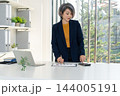 Businesswoman Standing at Desk Analyzing Financial Charts 144005191