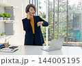 Businesswoman Checking Smartwatch on Phone Call by Office Window 144005195