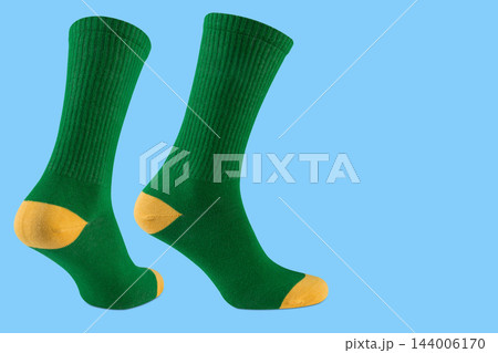 Pair of green sports socks with yellow heel on blue background, athletic promo banner mockup with copy space Pair of green sports socks with yellow heel on blue background, athletic promo banner mockup with copy space 144006170