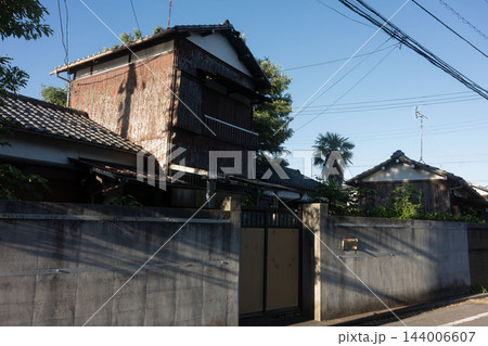 色あせた赤茶色の外壁と閉ざされた門扉、住宅街に残る昭和レトロな空き家 144006607