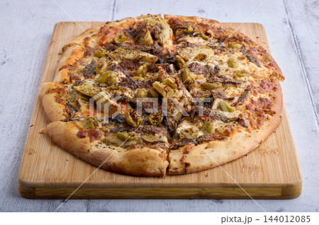 Homemade Pizza with Artichokes Olives Cheese and Herbs 144012085