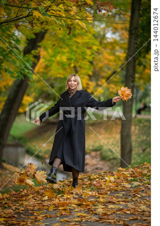 A smiling blonde woman in a black coat A smiling blonde woman in a black coat 144012674