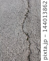 Cracked dry asphalt surface close up view. 144013862