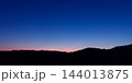 Sunset over silhouetted hilly horizon landscape. 144013875