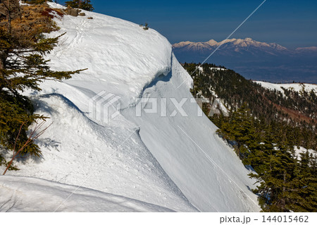 早春の根子岳稜線の雪庇と妙高・火打連峰 144015462