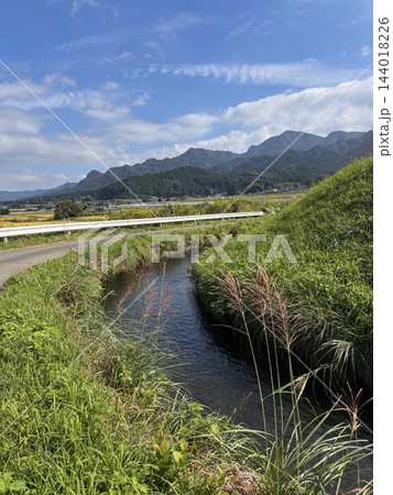 青空と阿蘇の山並み 水路とススキのある秋の田舎の風景 青空と阿蘇の山並み 水路とススキのある秋の田舎の風景 144018226