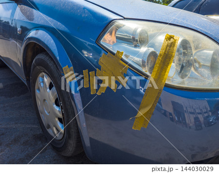 Blue car with yellow tape on bumper and headlight in Kyrgyzstan Blue car with yellow tape on bumper and headlight in Kyrgyzstan 144030029