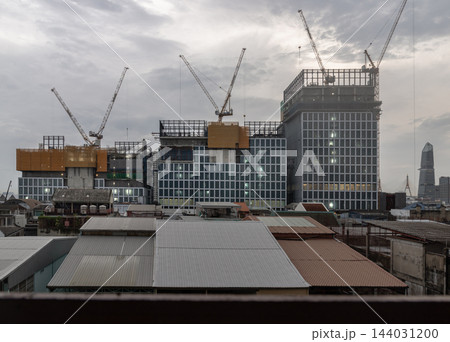 a new multi-tiered commercial development rising along Rama III Road on the historic site of the former Tawandang German Brewery. Towering construction cranes, multi-layered glass facades, and a new multi-tiered commercial development rising along Rama III Road on the historic site of the former Tawandang German Brewery. Towering construction cranes, multi-layered glass facades, and 144031200
