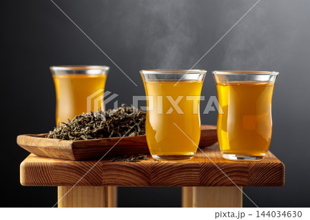 Green tea in small glass cups on an old wooden table. Green tea in small glass cups on an old wooden table. 144034630