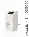 White digital socket timer with LCD screen isolated on white background. Energy Efficiency and Saving. 144035090