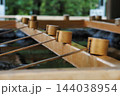 神社の手水舎に並ぶ柄杓と清らかな水 144038954