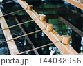 神社の手水舎に並ぶ柄杓と清らかな水 144038956