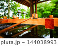 神社の手水舎に並ぶ柄杓と清らかな水 144038993