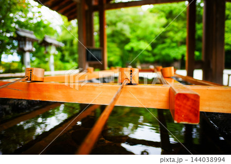 神社の手水舎に並ぶ柄杓と清らかな水 144038994