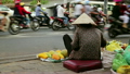 Vendor woman sitting and selling fruits on heavy hanoi traffic 12571559