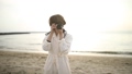 夕日の海辺でカメラを構える女性 29753173
