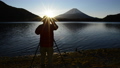 朝の精進湖で富士山の写真を撮影する男性 38706643