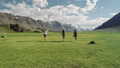 Group Of Friends Hold Hands And Run Away From Camera Toward Mountain 42046004