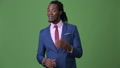 Young handsome African businessman with dreadlocks against green background 42359418