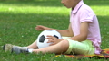 Lonely boy sitting in park with ball, no friends  46509699