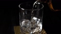 ウイスキーを氷の入ったグラスに注ぐ 48296603